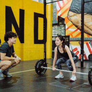 weightlifting coach and student practicing
