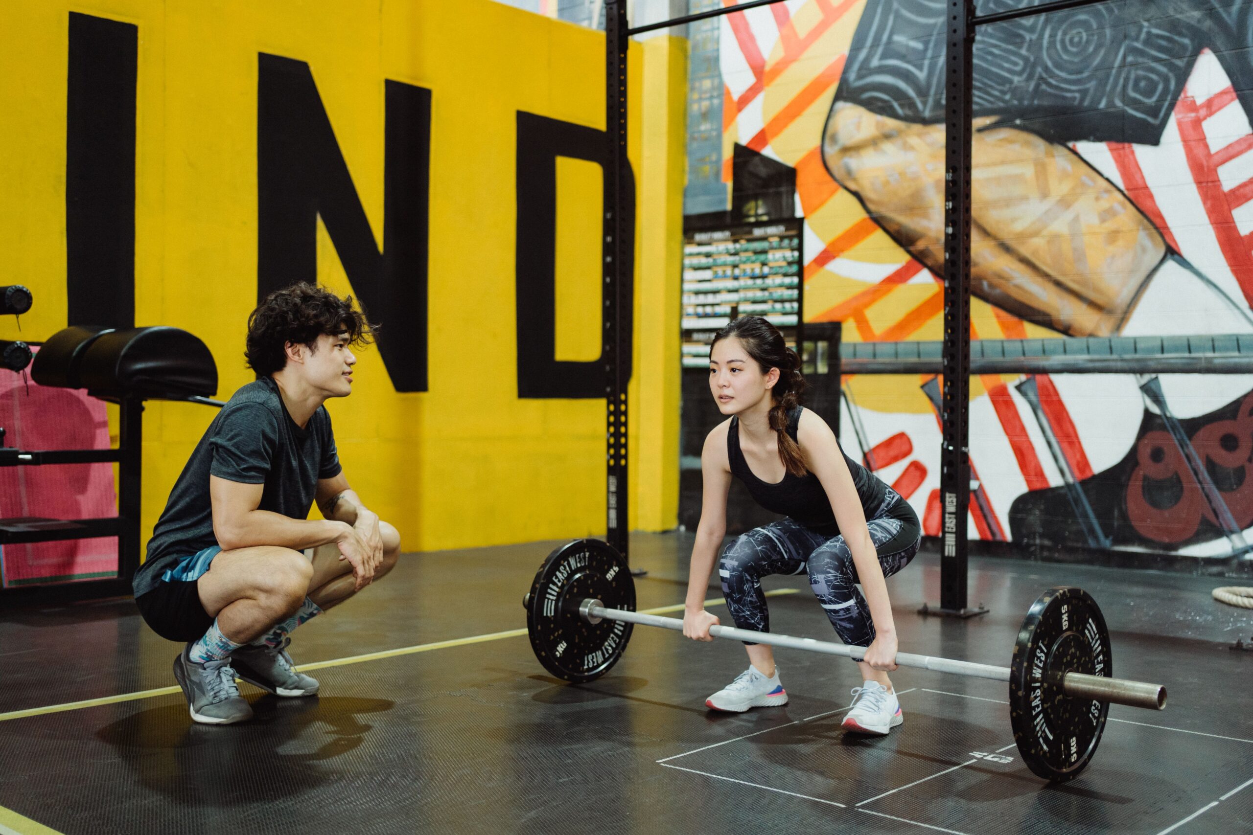 weightlifting coach and student practicing